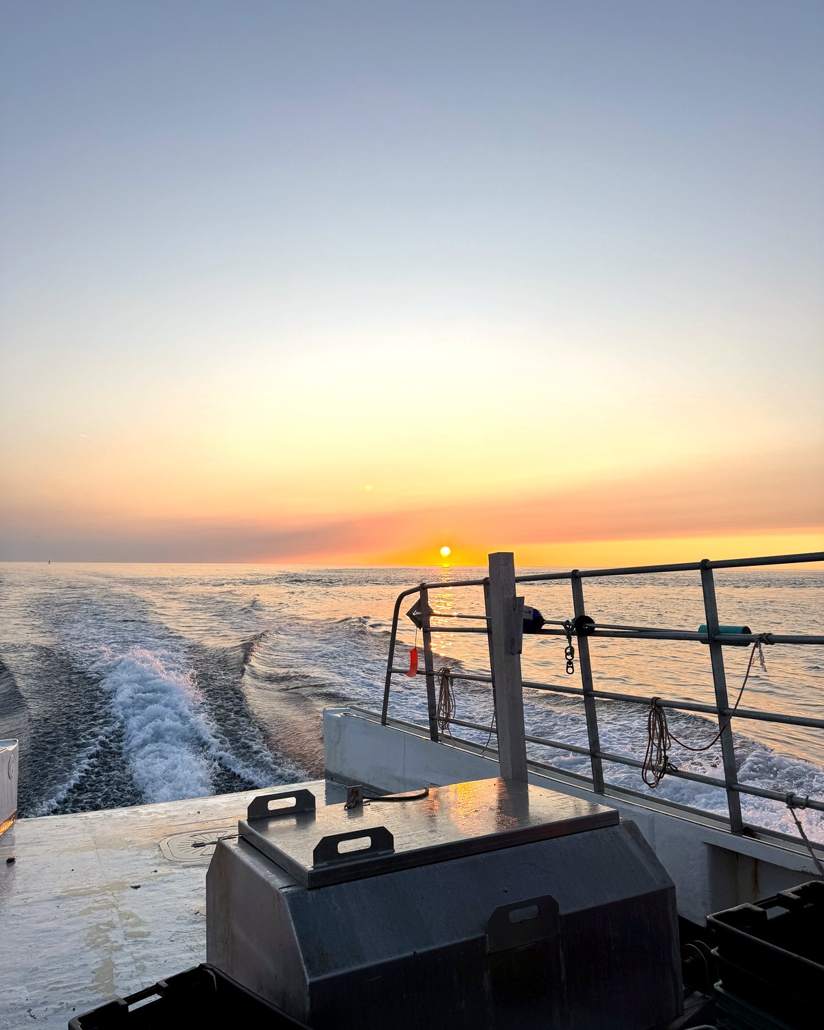 Sunset off the stern of a fishing boat