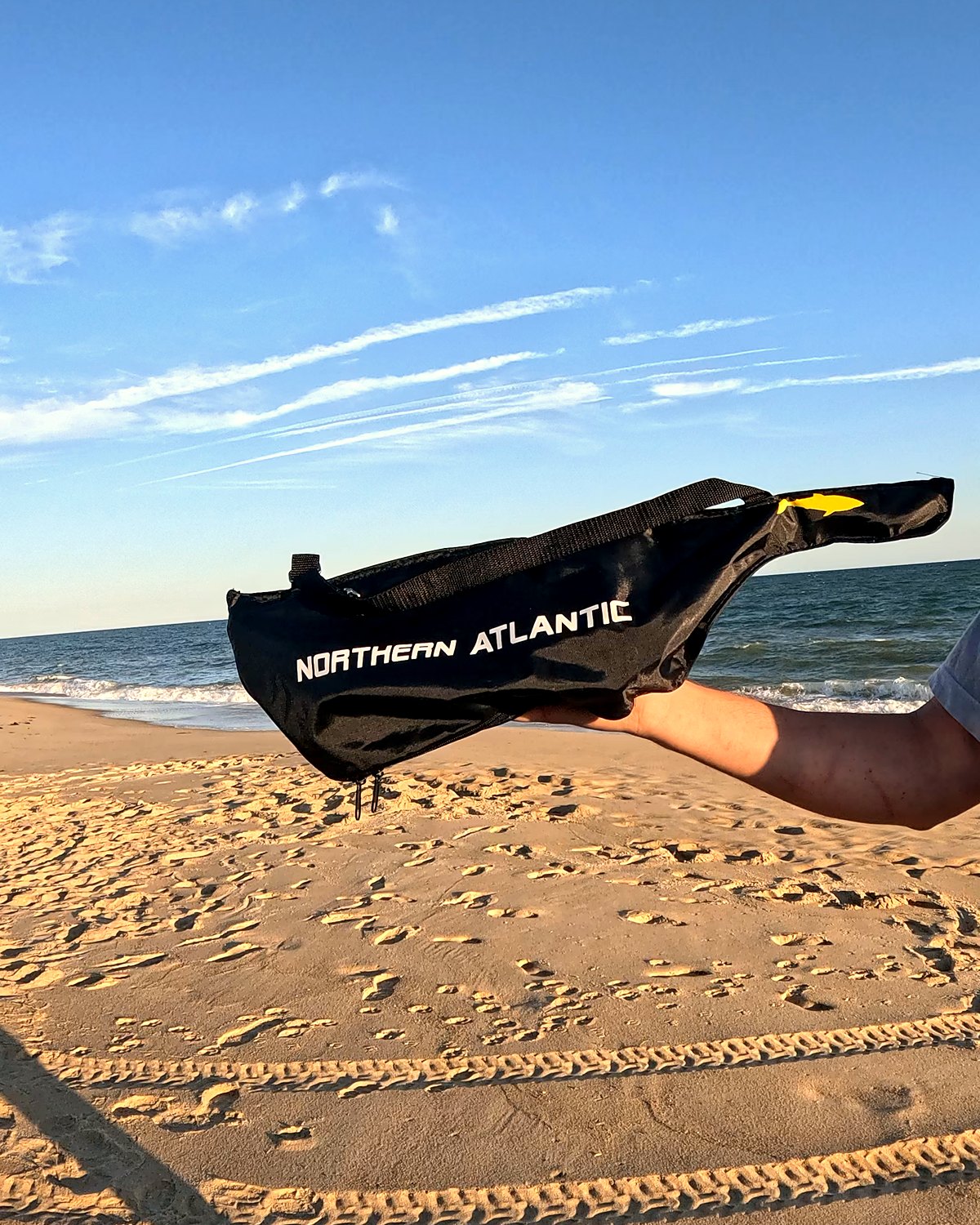 Travel combo bag held up on the beach